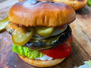 Mushroom burger with gherkin, lettuce, tomato and vegan cheese